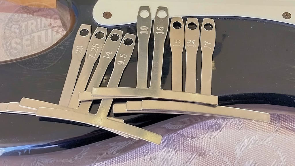 Set di radius gauge per chitarra con diversi valori di curvatura utilizzati per verificare e armonizzare l’action delle corde alla tastiera.