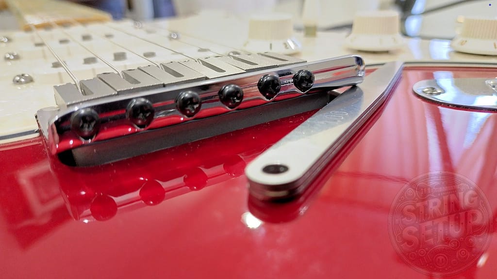 Misurazione di precisione dell'altezza del ponte tremolo su Stratocaster utilizzando uno spessimetro a lamine per un setup flottante perfetto.